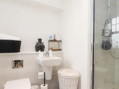 a white bathroom with a sink and a shower at Mellings Place in Carnforth