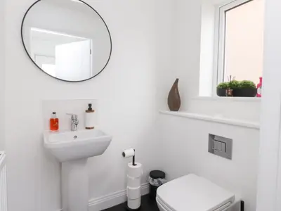 a white bathroom with a mirror and a toilet at Mellings Place in Carnforth