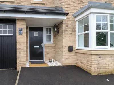 a brick house with a black door and window at Mellings Place in Carnforth