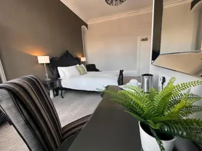 a hotel room with a bed and a table with a plant at Station lounge in Clitheroe