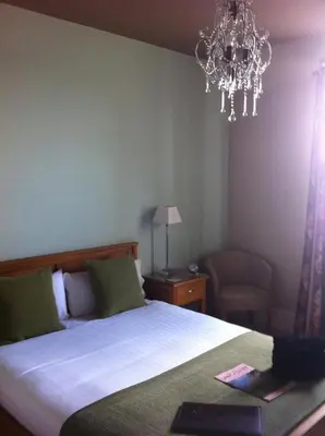 a bedroom with a bed and a chandelier at Station lounge in Clitheroe