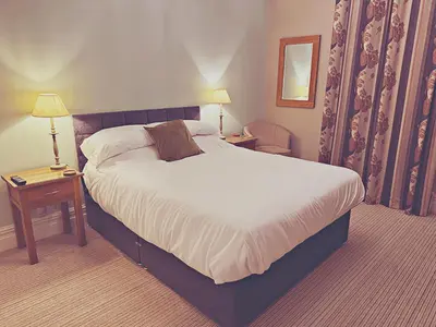 a hotel room with a large bed and two lamps at Station lounge in Clitheroe