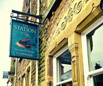 a sign for the station on the side of a building at Station lounge in Clitheroe