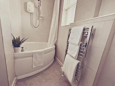 a white bathroom with a tub and a shower at Station lounge in Clitheroe