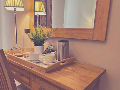 a wooden table with cups and saucers on it at Station lounge in Clitheroe