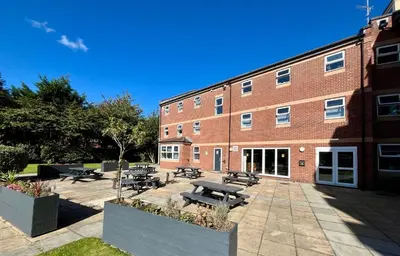 a brick building with picnic tables in front of it at For Students Only Myrtle Court in Liverpool in Liverpool
