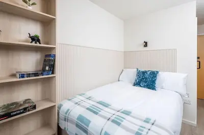 a small bedroom with a bed and shelves at For Students Only The Railyard in Liverpool in Liverpool