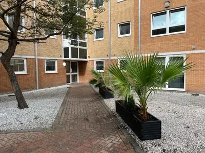 a brick building with two potted plants in front of it at For Students Only The Railyard in Liverpool in Liverpool