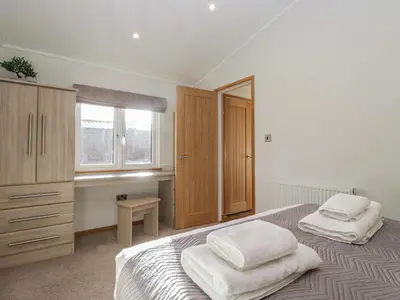 a bedroom with two white towels on a bed at Bluebell Lodge in Carnforth