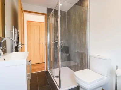 a bathroom with a shower and a toilet and a sink at Bluebell Lodge in Carnforth