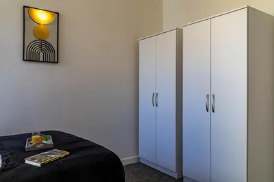 a bedroom with two white cabinets and a bed at One Bedroom Apartment by Brookland Stays Serviced Accommodation Short Lets Blackpool with Free WiFi in Blackpool