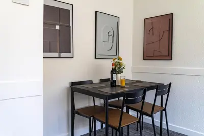 a black table with chairs and a vase of flowers on it at One Bedroom Apartment by Brookland Stays Serviced Accommodation Short Lets Blackpool with Free WiFi in Blackpool