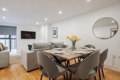 a dining room with a table and chairs and a couch at Stunning Central 2 bed Apt, 2 Baths in Liverpool