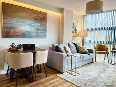 a living room with a couch and a table at Central, Stylish 2BR Flat Sleeps 6 with Parking! in Liverpool