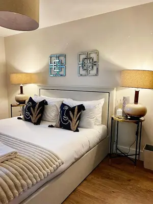 a bedroom with a bed with pillows and two lamps at Central, Stylish 2BR Flat Sleeps 6 with Parking! in Liverpool