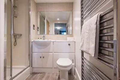 a bathroom with a toilet and a shower and a sink at Central, Stylish 2BR Flat Sleeps 6 with Parking! in Liverpool