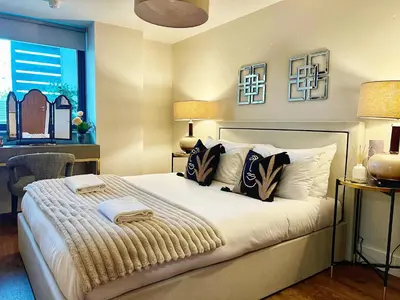 a bedroom with a bed and a desk and a window at Central, Stylish 2BR Flat Sleeps 6 with Parking! in Liverpool