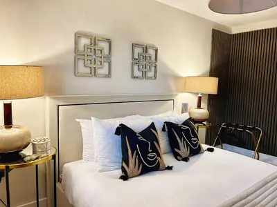 a bedroom with a bed with black and white pillows at Central, Stylish 2BR Flat Sleeps 6 with Parking! in Liverpool