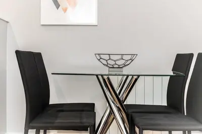 a glass table with two chairs and a bowl on top at Modern 2BR Flat, City Centre, Balcony & Parking! in Liverpool