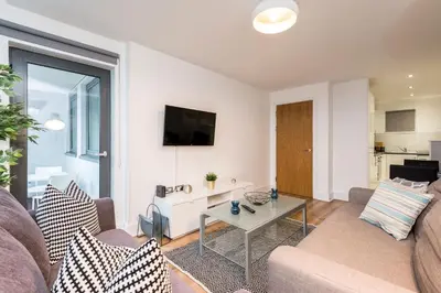 a living room with a couch and a table at Modern 2BR Flat, City Centre, Balcony & Parking! in Liverpool