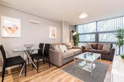 a living room with a couch and a table at Modern 2BR Flat, City Centre, Balcony & Parking! in Liverpool