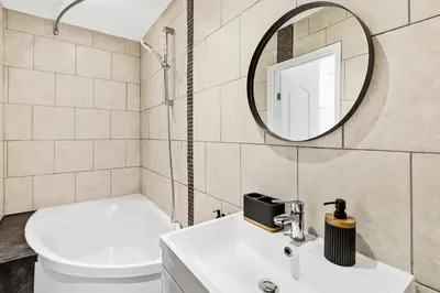 a bathroom with a toilet and a sink and a mirror at Spacious 3B Home, ideal for contractors & family! in Clayton le Moors