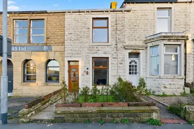 an old brick building with a red door at Spacious 3B Home, ideal for contractors & family! in Clayton le Moors