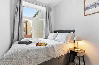 a bedroom with a bed with a bowl of fruit on it at Spacious 3B Home, ideal for contractors & family! in Clayton le Moors