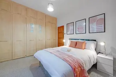 a bedroom with a large bed and wooden cabinets at Home in Anfield in Liverpool