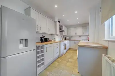 a large white kitchen with white cabinets and appliances at Home in Anfield in Liverpool