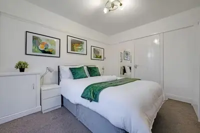 a bedroom with a large white bed with green pillows at Home in Anfield in Liverpool