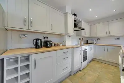 a large white kitchen with white cabinets and appliances at Home in Anfield in Liverpool