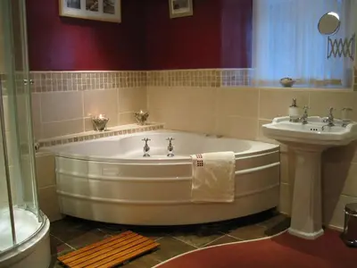 a bath tub and a sink in a bathroom at Rock Cottage - Log burners and jacuzzi bath in Lindale