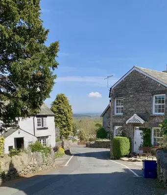 a house with a tree and a driveway at Rock Cottage - Log burners and jacuzzi bath in Lindale