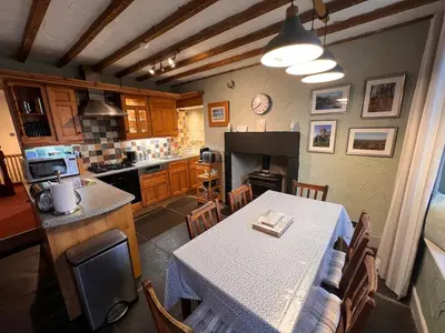 a kitchen and dining room with a table and a counter at Rock Cottage - Log burners and jacuzzi bath in Lindale