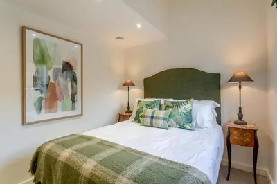 a bedroom with a bed with a green headboard and two lamps at 2 Bed in Dunsop Bridge oc-w33524 in Newton