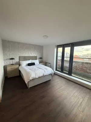 a bedroom with a large bed and a large window at Liverpool City Centre - Skyline Apartment in Liverpool