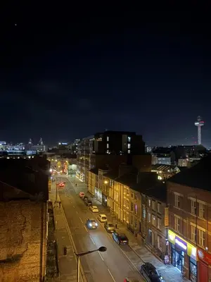 a city street at night with cars and buildings at Liverpool City Centre - Skyline Apartment in Liverpool
