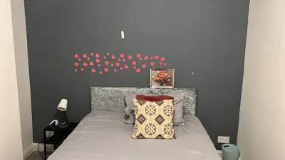 a bedroom with a bed with a bunch of red hearts on the wall at Regina Pacis contractor place near the city in Liverpool