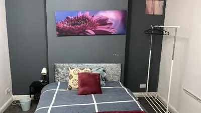 a bedroom with a bed with a pink flower on the wall at Regina Pacis contractor place near the city in Liverpool