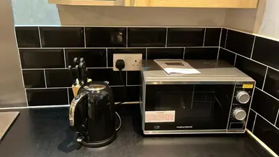 a kitchen counter with a toaster and a microwave at Regina Pacis contractor place near the city in Liverpool