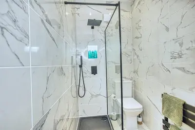 a white bathroom with a shower and a toilet at Central 2 beds APT with FREE parking, Sleeps 6 in Liverpool