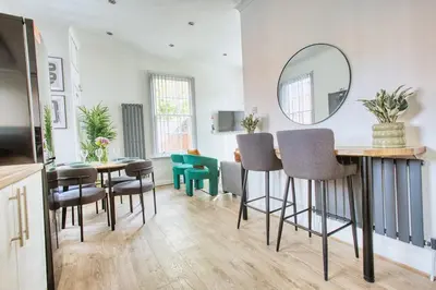 a dining room with a mirror and a table and chairs at Central 2 beds APT with FREE parking, Sleeps 6 in Liverpool
