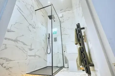 a bathroom with a shower with marble walls at Central 2 beds APT with FREE parking, Sleeps 6 in Liverpool