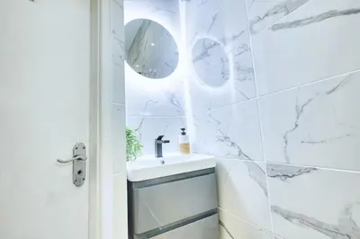 a white bathroom with a sink and a shower at Central 2 beds APT with FREE parking, Sleeps 6 in Liverpool