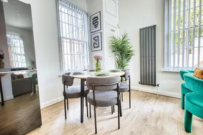 a living room with a table and chairs and a couch at Central 2 beds APT with FREE parking, Sleeps 6 in Liverpool