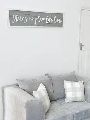 a gray couch with a sign that says there is no place like home at Modern 3-Bed House Near Attractions & Beach in Blackpool