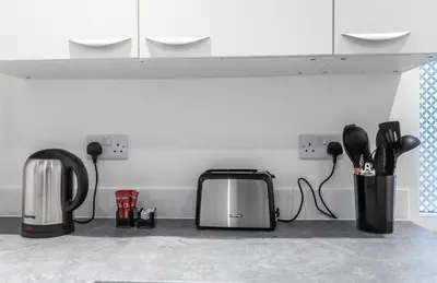 a kitchen counter with a toaster and utensils at 5 Bed Stay For Contractors And Families in Morecambe