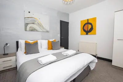 a bedroom with a large white bed with pillows at Delamore Place Cozy Home 3BR near City in Liverpool