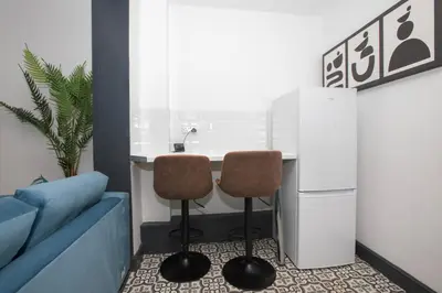 a kitchen with a counter and two stools at Delamore Place Cozy Home 3BR near City in Liverpool